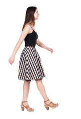 back view of walking  woman .