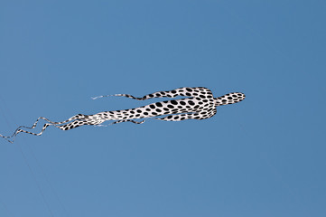 Grande aquilone in volo di sagoma umana contro cielo azzurro © lucioganci