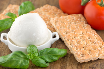 Tomato and mozzarella with basil leaves on a plate