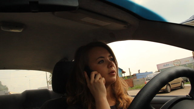 Young girl talking on the phone while driving  