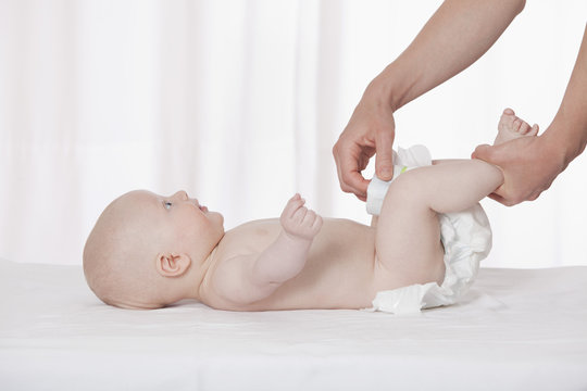 Germany, Munich, Mother changing diaper of months baby boy