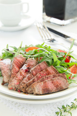 roast beef with salad of arugula and tomatoes.