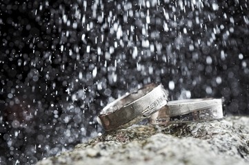 Two gold wedding rings with raindrops