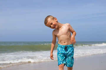 Laughing boy on beach after a swim