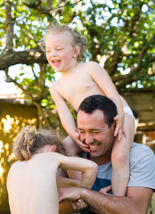 Fototapeta premium Father playing with his daughters