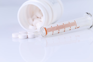 Syringe and medicaments on white background.