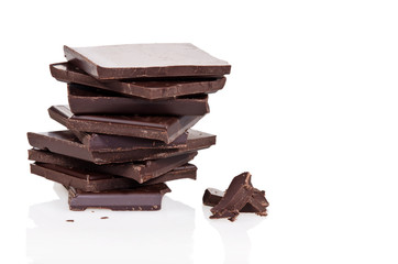 Dark chocolate pieces in stack over white background
