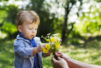 child sees a bouquet of flowers in their hands mom outdoors
