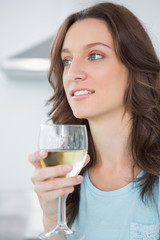 Thoughtful brunette drinking white wine