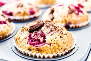 Festive chocolate small cakes with cherry  in baking tray. Close