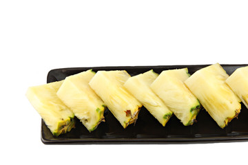 Pineapple slice in the black dish.