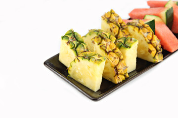 Pineapple and Watermelon slice Arranged in the black dish.