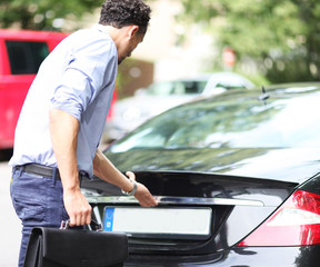 Mann öffnet Kofferraum