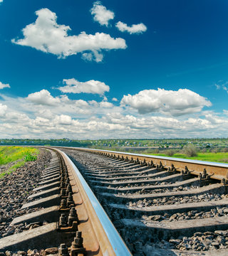 Fototapeta zbliżenie kolei do horyzontu i ciemnoniebieskie niebo z chmurami