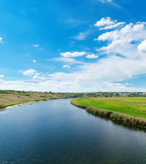 Obraz na płótnie Canvas river with reflections and blue cloudy sky