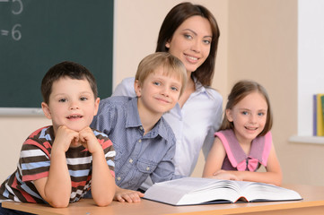 Fototapeta na wymiar Teacher and pupils. Confident young teacher sitting together wit