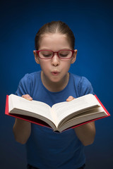 Pretty schoolgirl with book. Pretty little girl in glasses holdi