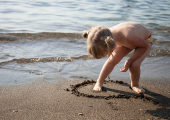 Pretty little girl playing on the seashore