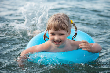 Fototapeta na wymiar Smiling little girl swimming