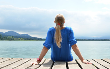 Fototapeta premium Girl on the wooden jetty. Switzerland