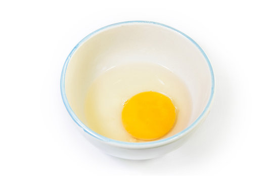 The cracked egg in ceramic bowl with isolated white background