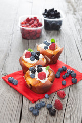 Tasty cupcakes with berries on wooden table
