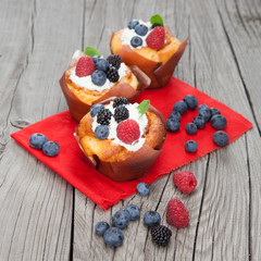 Tasty cupcakes with berries on wooden table