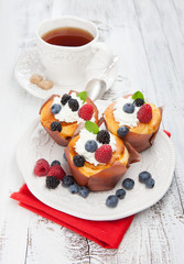 Tasty cupcakes with berries on wooden table