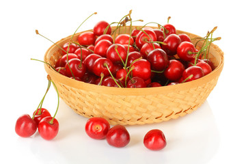 Cherry berries in wicker basket isolated on white