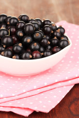 Fresh black currant on wooden background