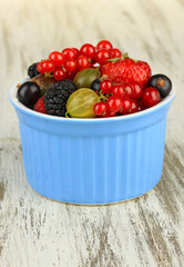 Ripe berries in bowl on table close-up