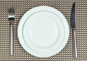 Knife, color plate and fork, on color background