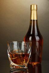 Glass of whiskey with bottle, on dark background