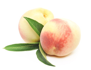 ripe peach fruits with green leaves