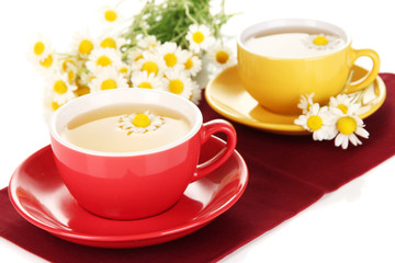 Fototapeta premium Cups of herbal tea with camomiles close up