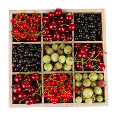 Different summer berries in wooden crate isolated on white