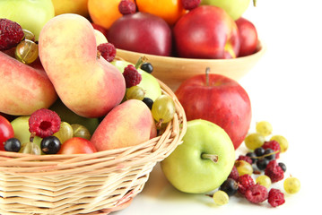 Naklejka na ściany i meble Assortment of juicy fruits in wicker basket and wooden bowl,
