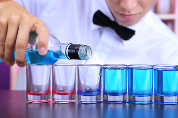 Bartender is pouring liquor into glass