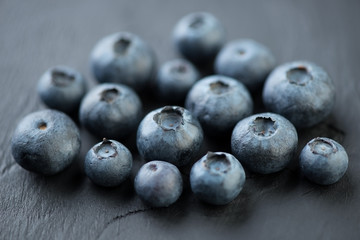 Ripe blueberries on black wooden background