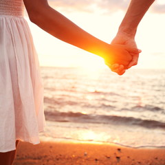 Love - romantic couple holding hands, beach sunset