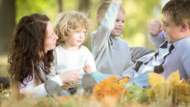 Happy family playing outdoors in autumn park. Dolly shot