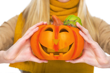 Closeup on jack-o-lantern in hand of young woman