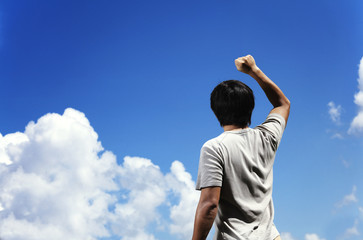 Fototapeta na wymiar Man clench fist facing the sky