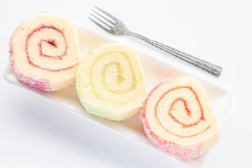 Dish of colorful jam roll cakes with fork