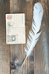 old letters and a quill on wood