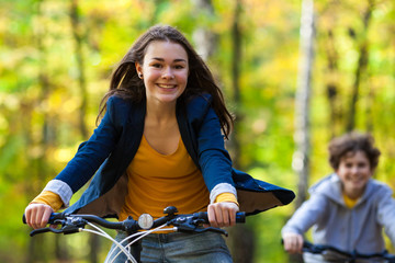 Fototapeta na wymiar Urban biking - teens riding bikes in city park