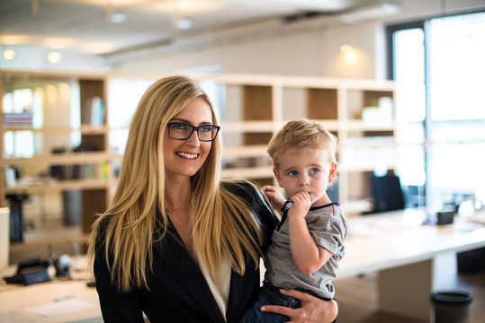 Businesswoman with small child in the office