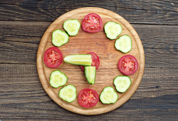 Fresh tomato and cucumber in the shape of clock