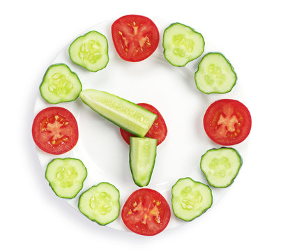 Slices cucumber and tomato in the shape of clock