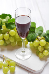 Red wine and grapes on wooden background